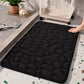 Gros plan sur texture galets du tapis de bain