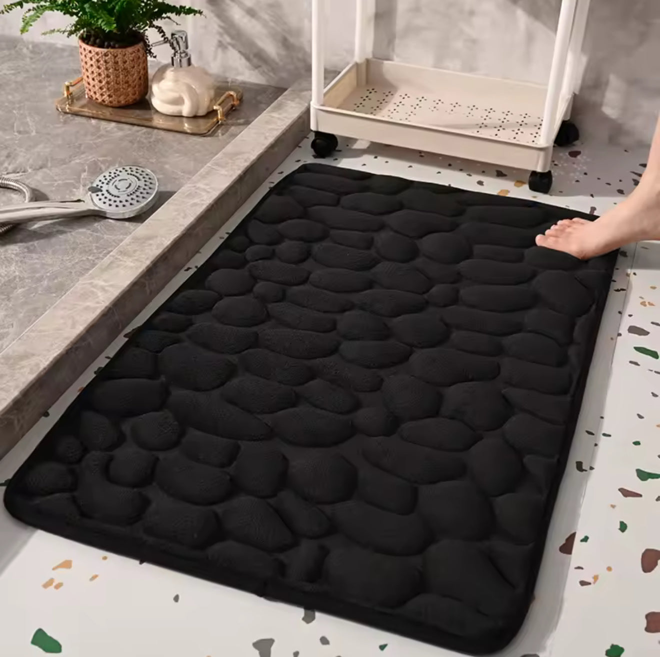 Gros plan sur texture galets du tapis de bain