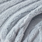 Jeté polaire bleu drapé sur un fauteuil moderne