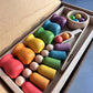 Poupées en bois pastel alignées sur un plateau de jeu