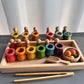 Boules en bois multicolores à côté de pots assortis