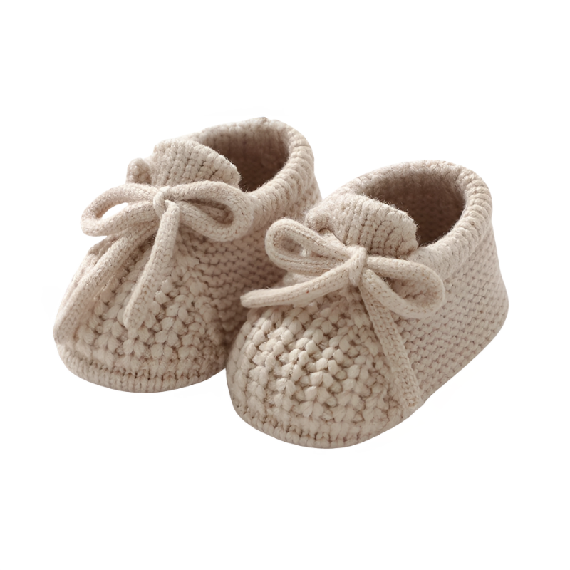 Chaussons bébé tricotés couleur marron clair, sur fond neutre
