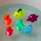 Main d'enfant tenant un dinosaure de bain lumineux