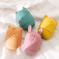 Main d'enfant tenant un jouet de bain en silicone coloré