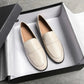 Mocassins en cuir noir sur fond blanc minimaliste