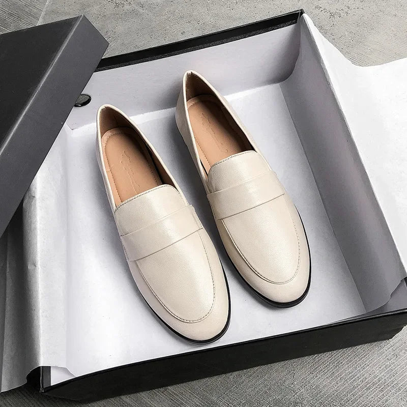 Mocassins en cuir noir sur fond blanc minimaliste