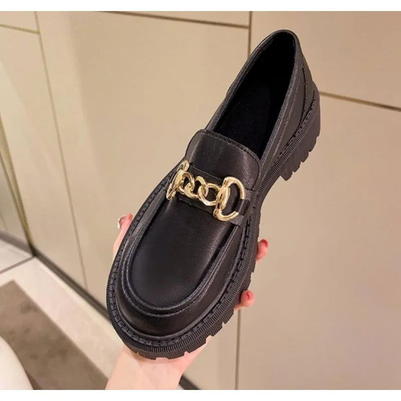 Détail de la chaîne dorée sur mocassins élégants