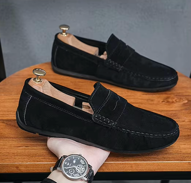 Mocassins en daim posés à côté d'une boîte à chaussures