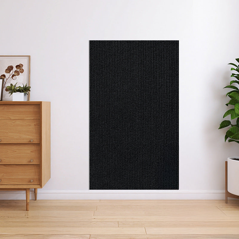 Tapis anti-griffes noir sur un canapé en tissu sombre