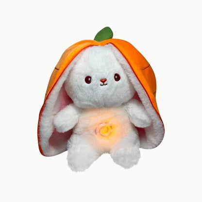 Peluche lapin veilleuse lumineuse orange, posée sur un lit