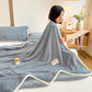 Plaid moelleux en pilou pilou sur un lit ou fauteuil