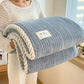 Plaid bleu en pilou pilou sur un canapé confortable