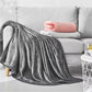 Plaid gris moelleux en tissu ultra doux sur un canapé