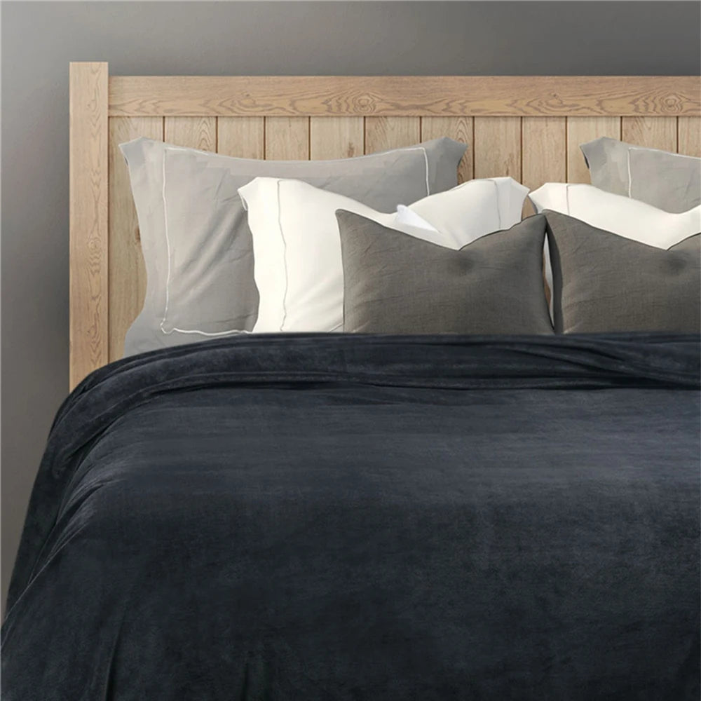 Plaid noir moelleux sur canapé clair, ambiance cocooning