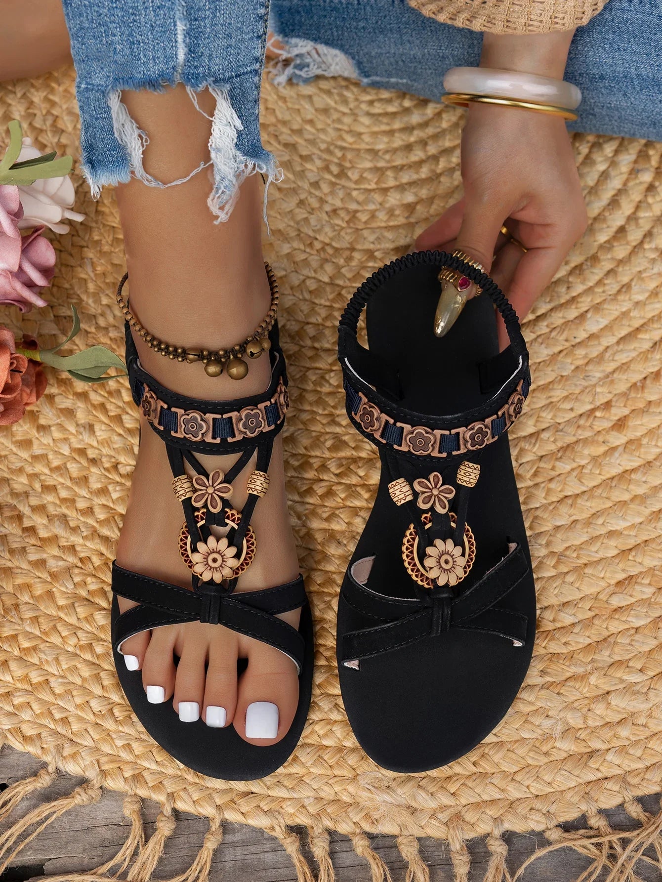 Sandales noires plates avec détails floraux et perles