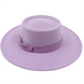 Homme assis, portant un fedora crème, ambiance décontractée