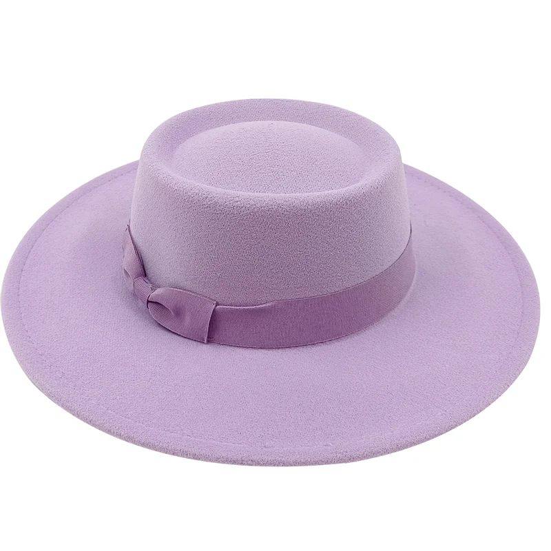 Homme assis, portant un fedora crème, ambiance décontractée