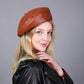 Femme souriante portant un béret en cuir, vue de face