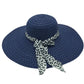 Chapeau de paille sur fond sable, ambiance estivale