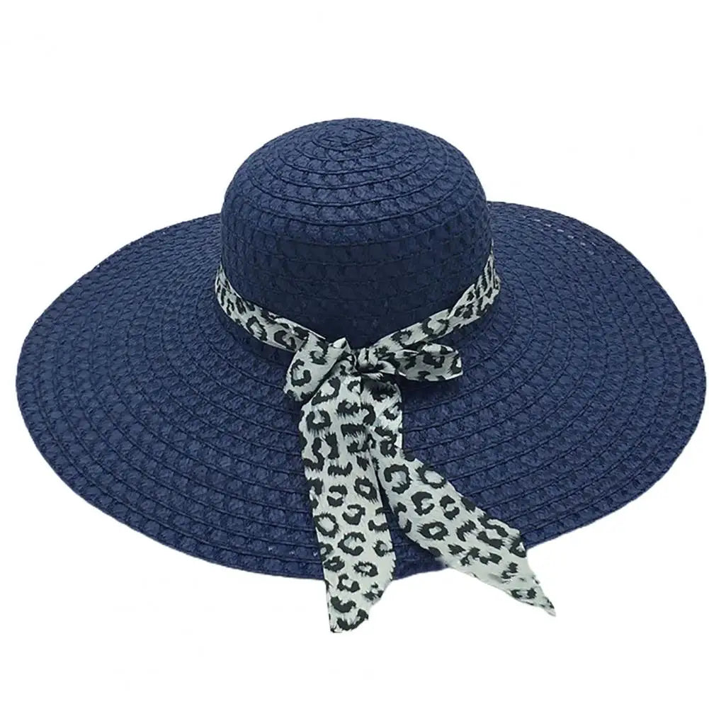 Chapeau de paille sur fond sable, ambiance estivale