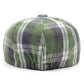 Casquette gavroche à carreaux posée sur une surface en bois