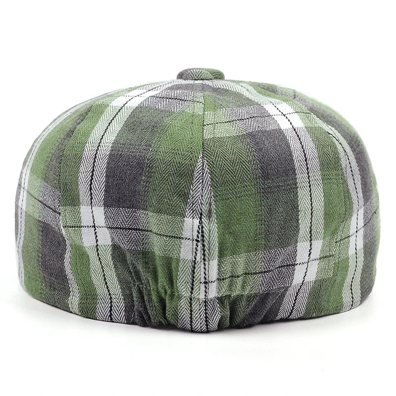 Casquette gavroche à carreaux posée sur une surface en bois