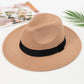 Chapeau Fedora beige accroché à un porte-manteau