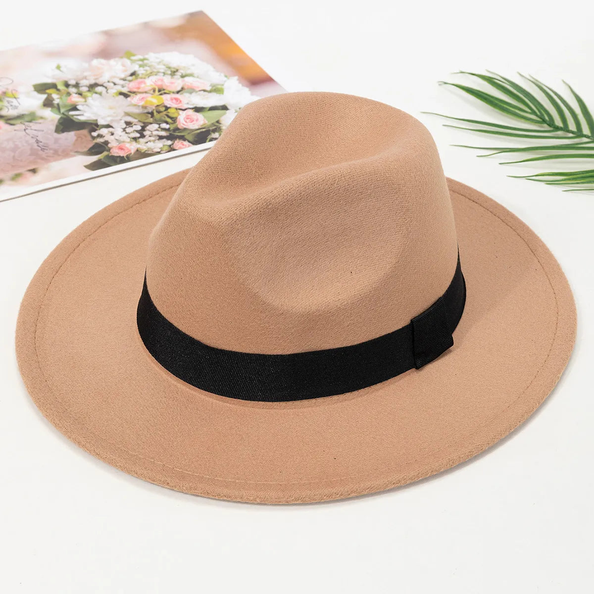 Chapeau Fedora beige accroché à un porte-manteau