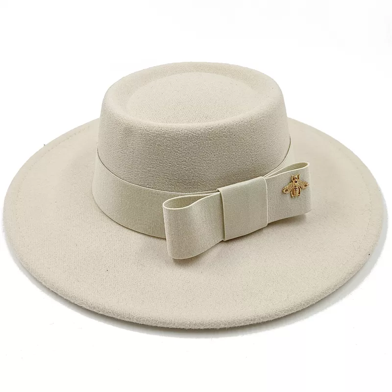 Chapeau beige en coton, accroché à un crochet mural