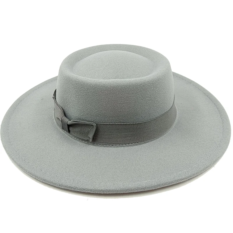 Homme en costume avec un fedora gris, regard pensif