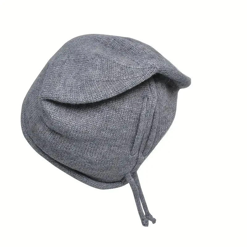 Femme ajustant un bonnet en maille torsadée devant un miroir