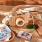 Enfant souriant tenant l'appareil photo en bois