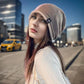 Femme souriante avec un bonnet long en extérieur enneigé
