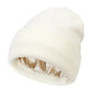 Bonnet en satin noir posé sur une table en bois
