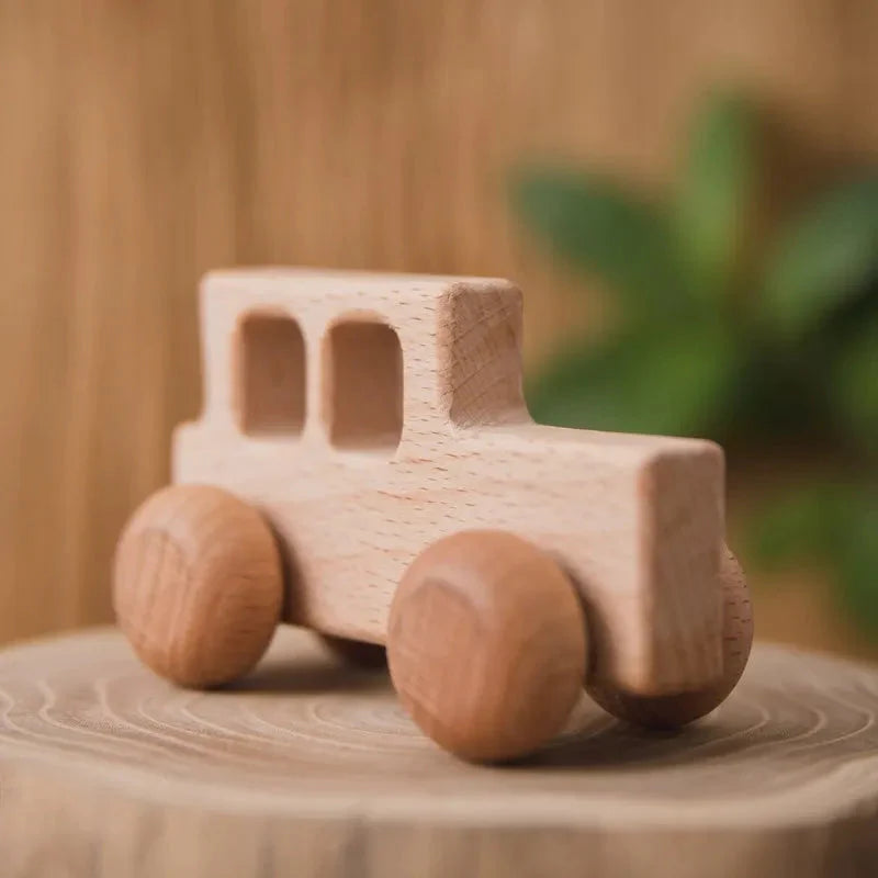 Voiture en bois montrée dans une main d'adulte