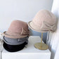 Femme portant un chapeau cloche beige, style rétro chic