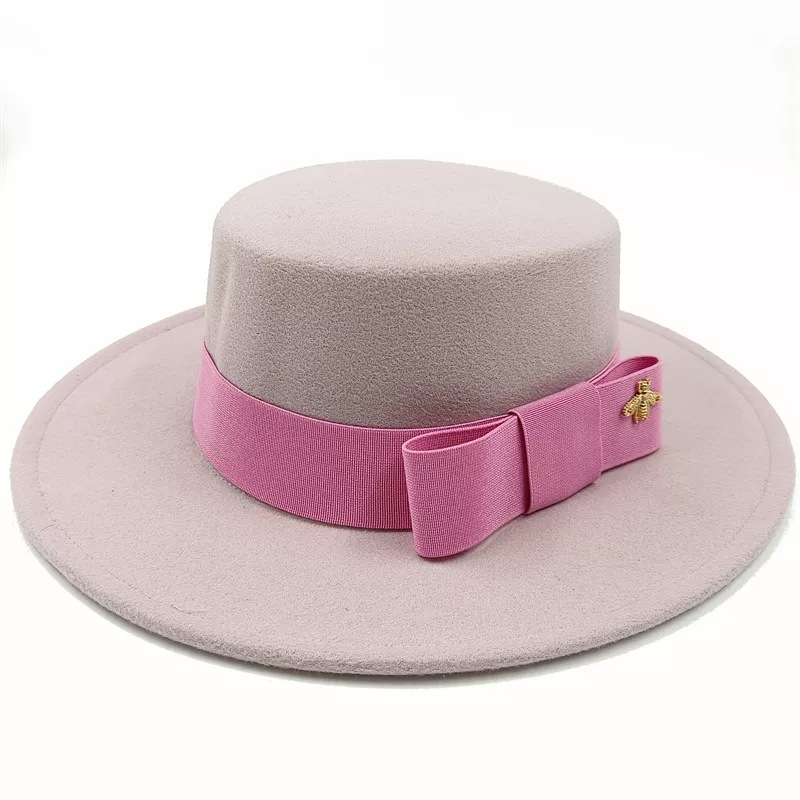 Chapeau beige avec un nœud, sur une surface en bois