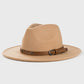 Jeune homme assis sur un banc, portant un Fedora en laine, regardant au loin