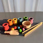 Poupées en bois pastel rangées dans des pots assortis