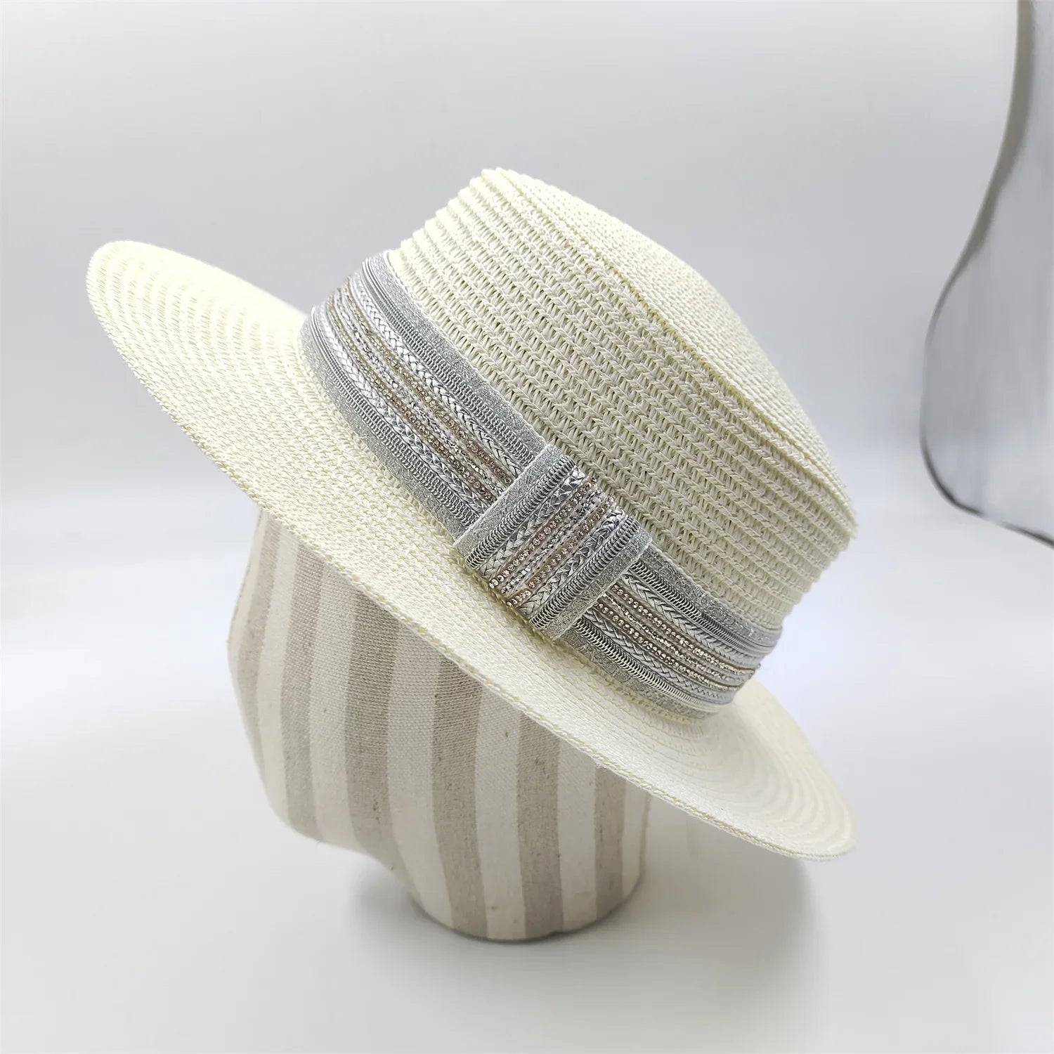Chapeau de paille avec ruban blanc, posé sur l'herbe