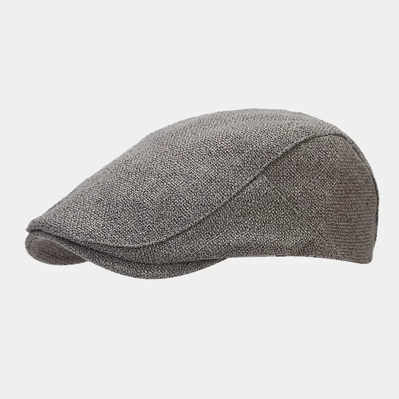 Béret noir sur une surface en marbre, ombre portée