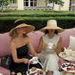 Chapeau de paille extra-large posé sur une table en bois