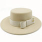 Chapeau beige avec un nœud, posé sur une chaise