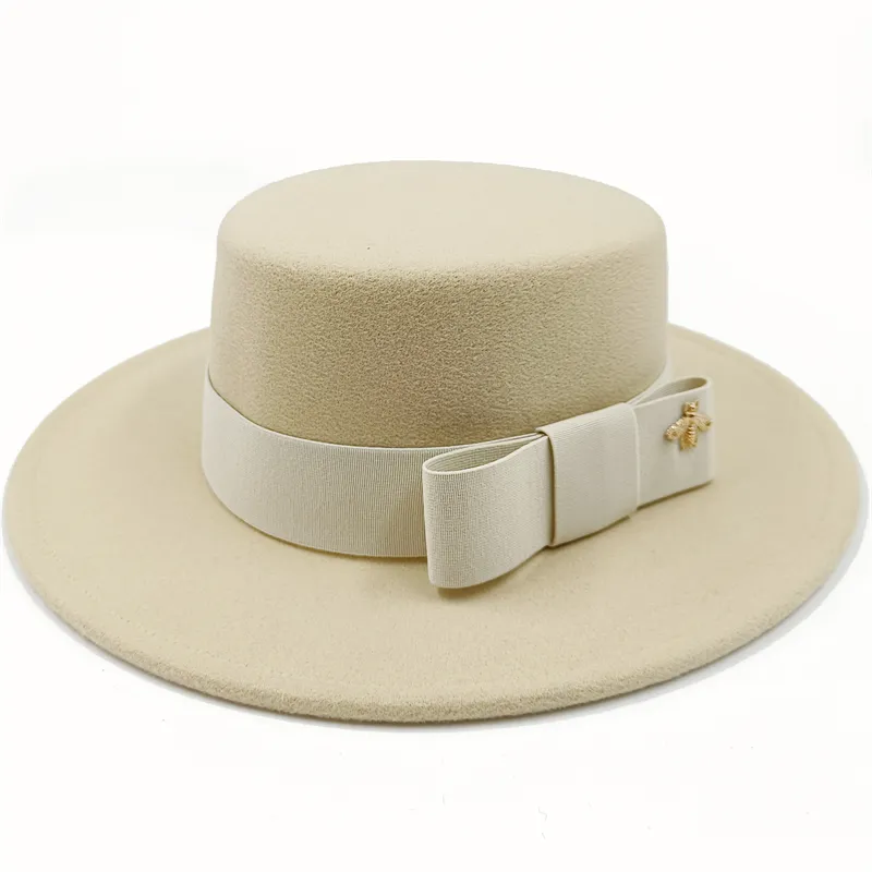 Chapeau beige avec un nœud, posé sur une chaise