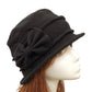 Chapeau cloche en feutre beige avec ruban noir, posé sur une table