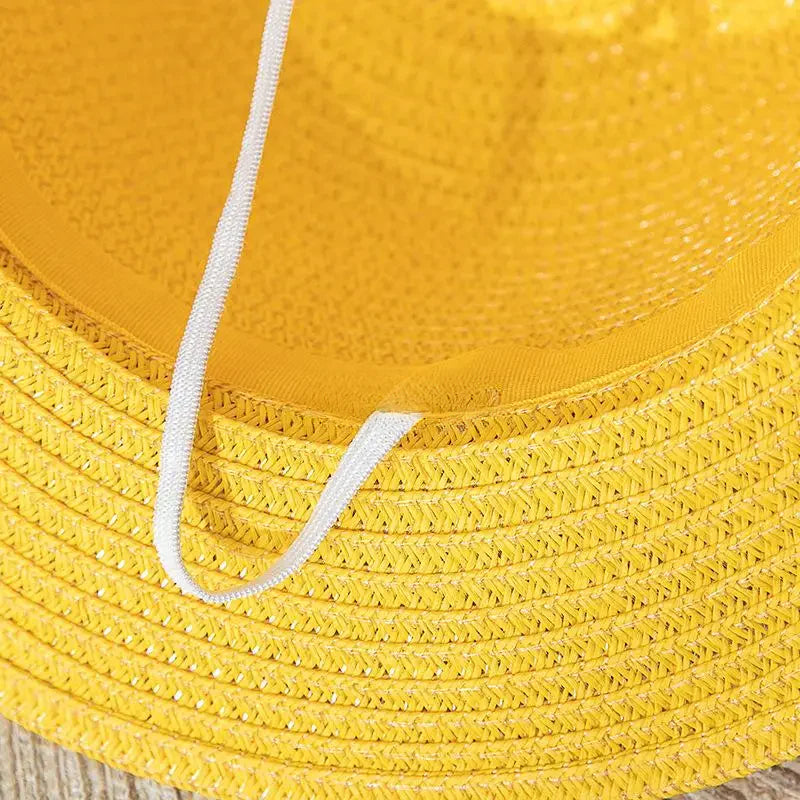 Chapeau de paille avec ruban noir sur fond blanc