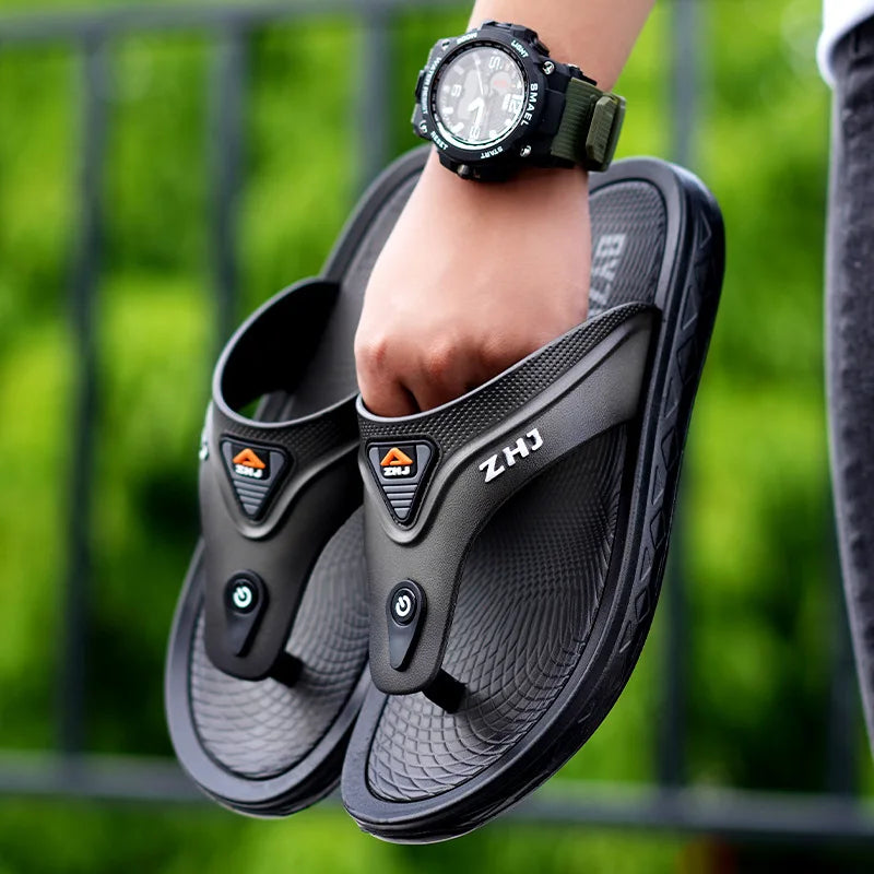 Tongs noires avec bouton décoratif sur le dessus