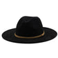 Chapeau Fedora marron posé sur une table en bois