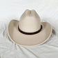 Chapeau cowboy posé sur une clôture en bois, ambiance rustique