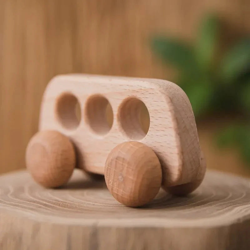 Enfant jouant avec la voiture en bois sur un tapis